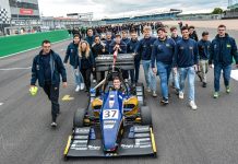 MoRe Modena Racing team members walking behind their car on the pit straight of Silverstone circuit